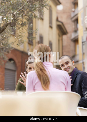 Friends sitting at a cafe in a piazza Stock Photo