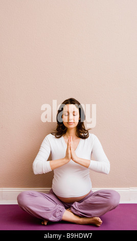 Pregnant woman doing yoga Stock Photo