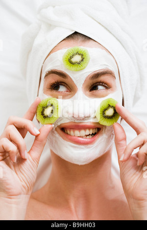 Woman with face mask and kiwi fruit Stock Photo