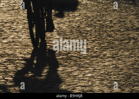Shadow of a cyclist on cobbled street