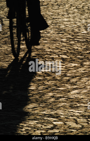 Shadow of a cyclist on cobbled street