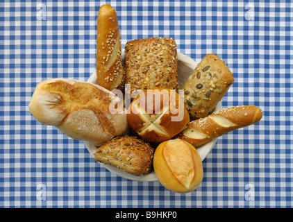Bread basket filled with different kinds of rolls and lye rolls on a blue and white checked table cloth Stock Photo