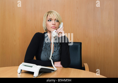 Woman on phone in boardroom Stock Photo