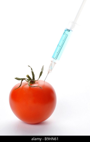 Syringe in a tomato, symbolic for genetically manipulated foods Stock Photo