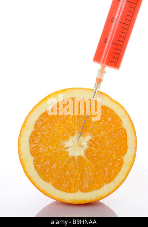 Syringe in an orange, symbol for genetically engineered food Stock Photo