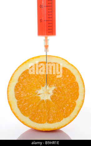 Injection needle in an orange, symbolic picture for genetically manipulated food Stock Photo