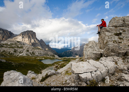 Man sitting on mountain peak Stock Photo