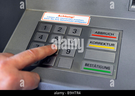 Person entering the PIN into a cash machine Stock Photo