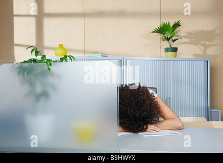 Woman asleep at desk in office Stock Photo