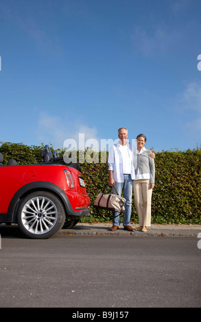 Mature couple standing next to car Stock Photo