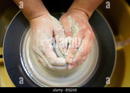 Potter forming a jug with her hands out of clay on a potter's wheel in her studio in Aalen, Baden-Wuerttemberg, Germany, Europe Stock Photo