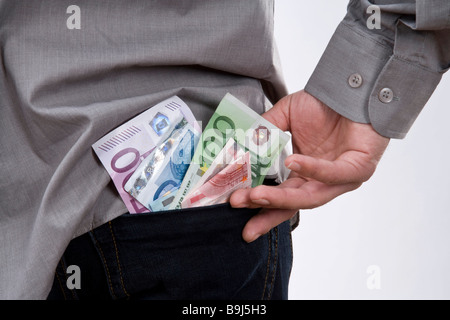 Euro banknotes sticking out of the trouser pocket of a young man Stock Photo