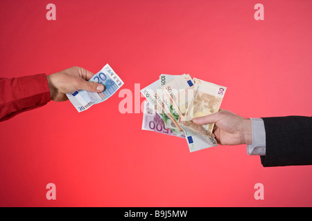 Two hands giving each other banknotes Stock Photo