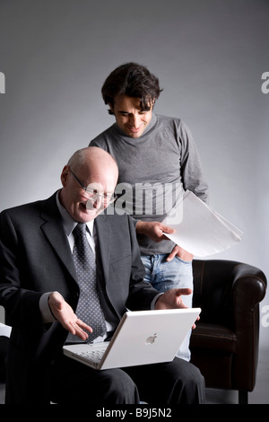 Businessman and assistant working on a laptop Stock Photo