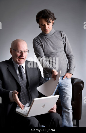 Businessman and assistant working on a laptop Stock Photo