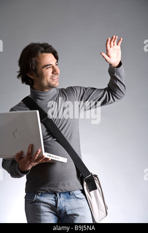 Waving younger dark skinned man sitting on a palm tree, Desroches Stock ...
