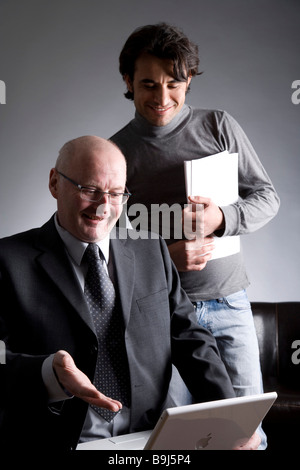 Businessman and assistant working on a laptop Stock Photo