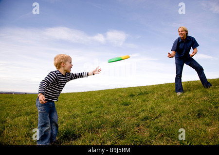 Boy and father play frisbee Stock Photo