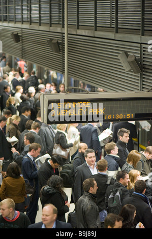 Commuters on crowded platform awaiting train Canary Wharf Docklands London United Kingdom Stock Photo