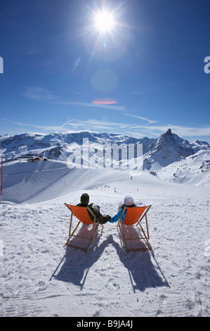 Couple reclining in deck chairs Stock Photo