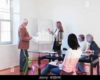 Co-workers giving presentation in office Stock Photo