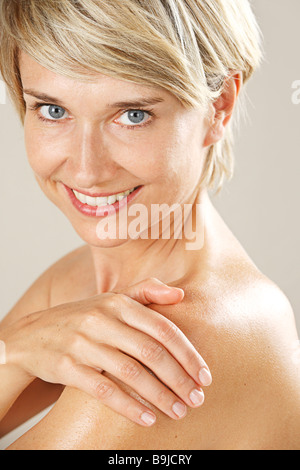 Woman rubbing her skin and shoulder with oil Stock Photo