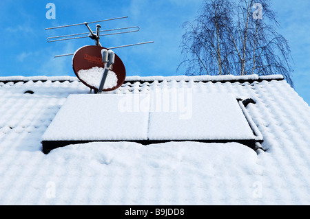 Snow-covered solar panels on a one-family-house, Eckental Valley, Middle Franconia, Bavaria, Germany, Europe Stock Photo