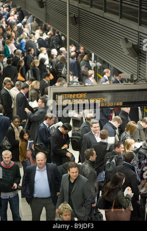 Commuters on crowded platform awaiting train Canary Wharf Docklands London United Kingdom Stock Photo