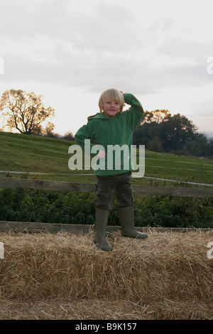 Young boy on hay bales Stock Photo