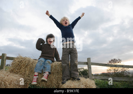 Young boys on hay bales Stock Photo