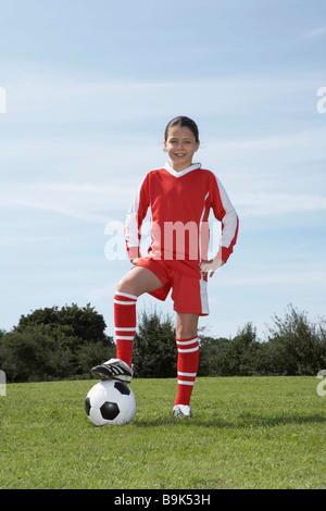 Female footballer standing with ball Stock Photo