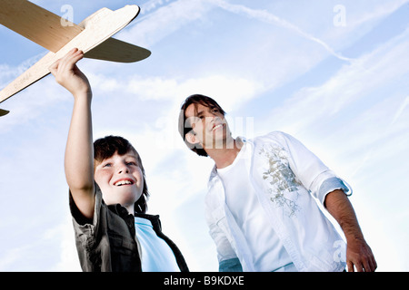 father watching as son is starting toy airplane Stock Photo