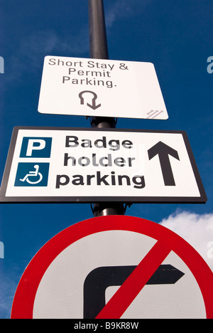 A traffic sign saying badge holder parking and short stay & permit parking and no right turn Stock Photo