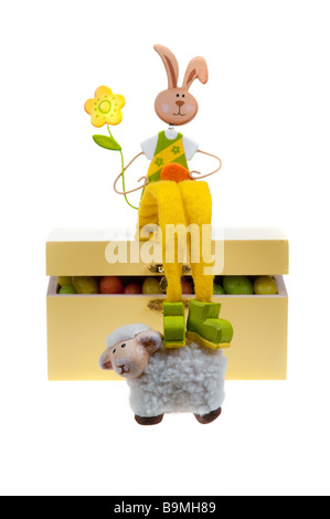 Easter bunny on a box full of easter eggs isolated on white Stock Photo