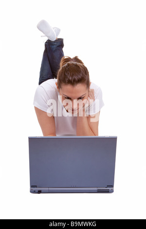Attractive young female lying down working on a laptop computer isolated on white background Stock Photo