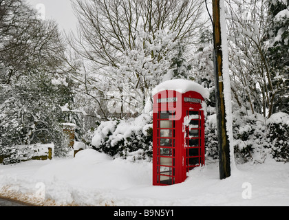 Old rural red telephone box in deep snow Stock Photo