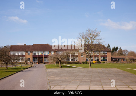 Front of modern Church of England primary school building exterior and grounds with long driveway. Tilford Surrey England UK Stock Photo