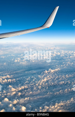 View through airliner window high above clouds