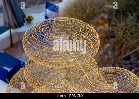 Cyclades, Santorini, Thira. Close up of four oval small fisherman's basket nets stacked up on seafront. Stock Photo