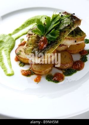 Pan fried gurnard with truffled new potato salad pea puree and salsa verde Stock Photo