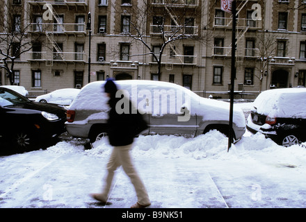 City street snow. Cars buried and man walking in the winter Stock Photo