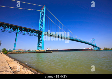 Large bulk carrier ship passing beneath the Ambassador Bridge which spans the Detroit River between the cities of Windsor. Stock Photo