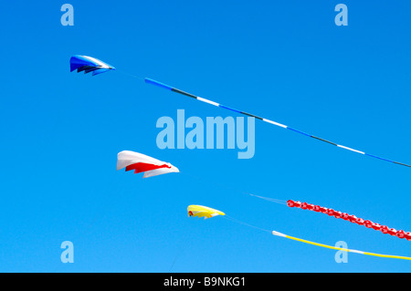 3 three colorful kites flying in the wind against a clear blue sky Stock Photo
