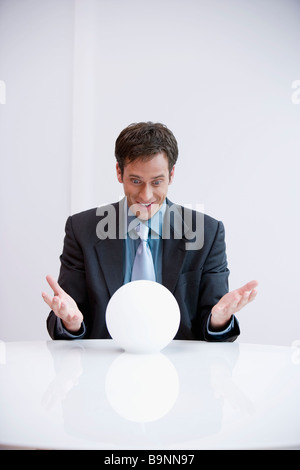 portrait of happy businessman looking into crystal ball Stock Photo - Alamy