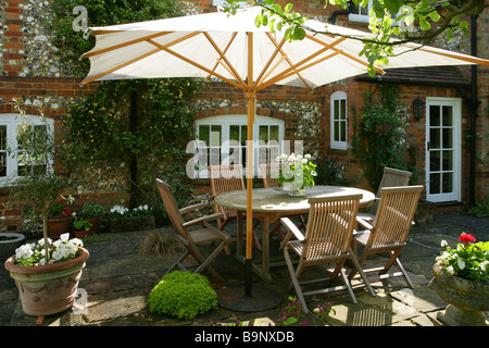 A domestic country summer scene. The photograph shows a patio of an English country house with an outside dining set.