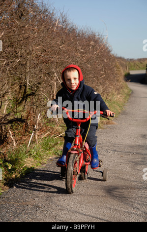 Young boy riding bicycle on track Marloes Pembrokeshire Wales UK Europe Stock Photo