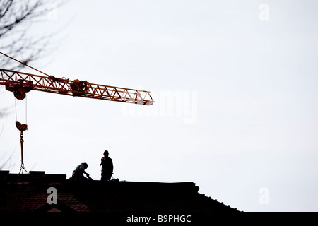Abstract image of construction workers working on rooftop Stock Photo