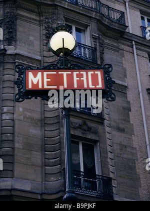 Iconic Metro underground sign at dusk with building in the background, Paris France Stock Photo