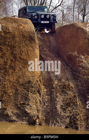 A Land Rover Defender 90 about to descend a steep hill on an offroad driving track in Sussex UK. Stock Photo