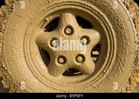 The muddy wheel of a Land Rover Defender 90 after driving through a flooded road Stock Photo